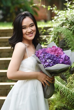 A person holding a bouquet of flowersDescription automatically generated with medium confidence